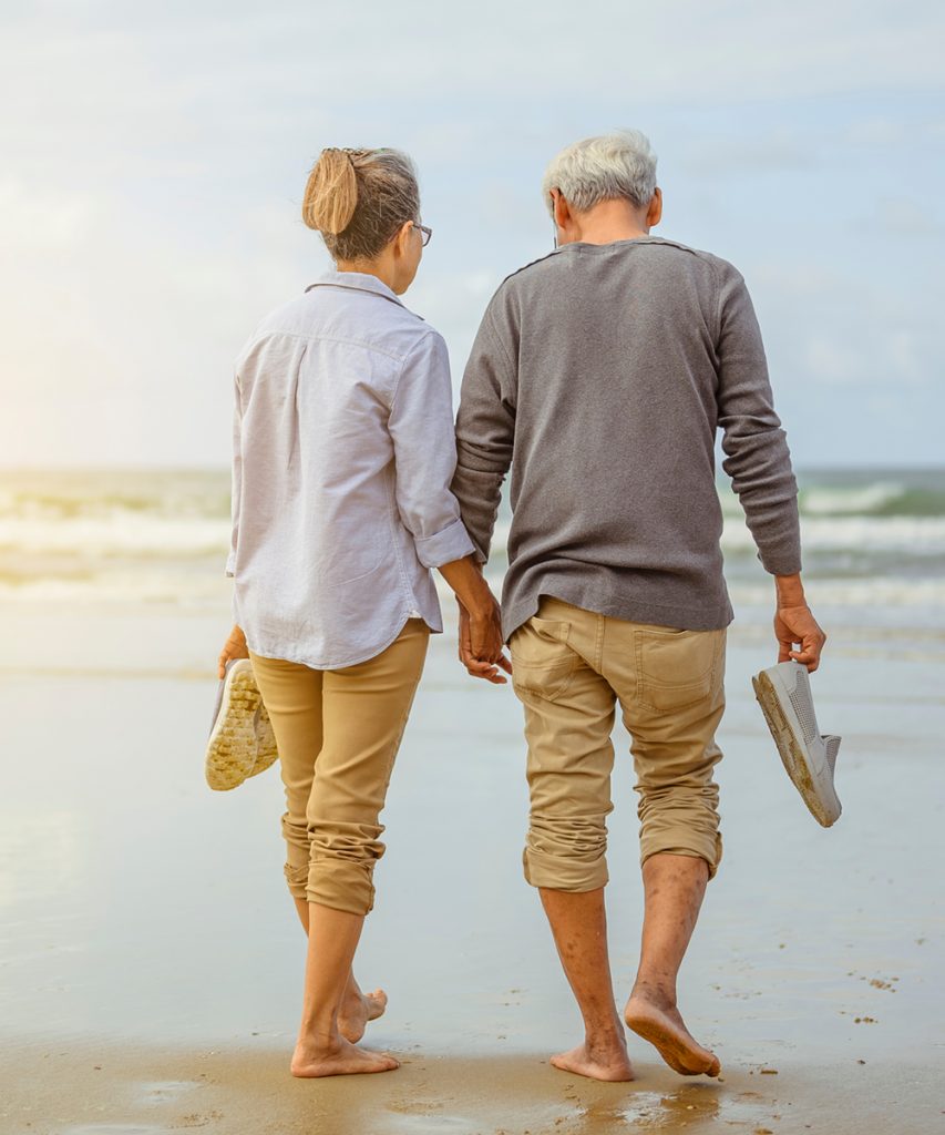 Retired couple walking by the beach